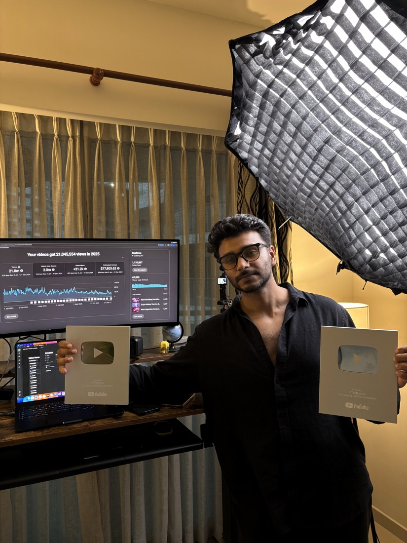 Alex holding two YouTube play buttons in front of his 21 million view dashboard